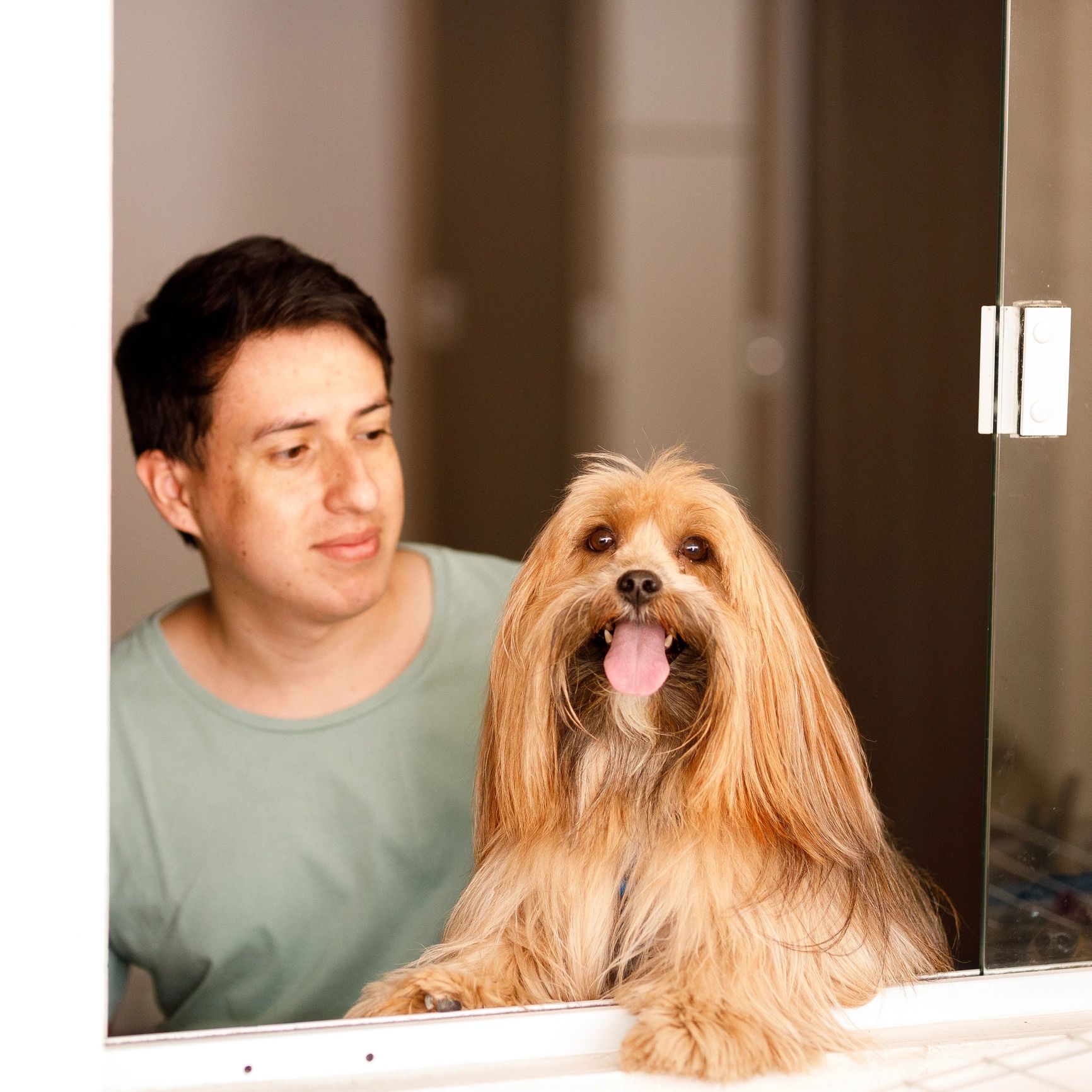 Man with his dog by a window