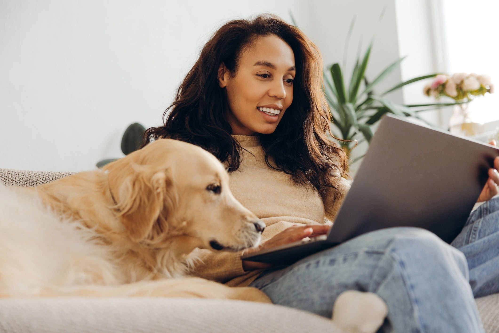 Pet care writer working on a laptop with a dog nearby